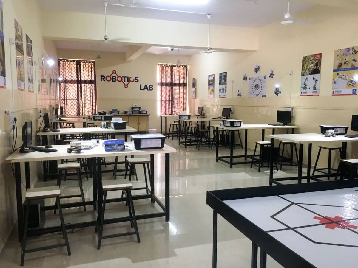 Robotics laboratory setup with student workstations, robotics kits, computers and a robot practice arena